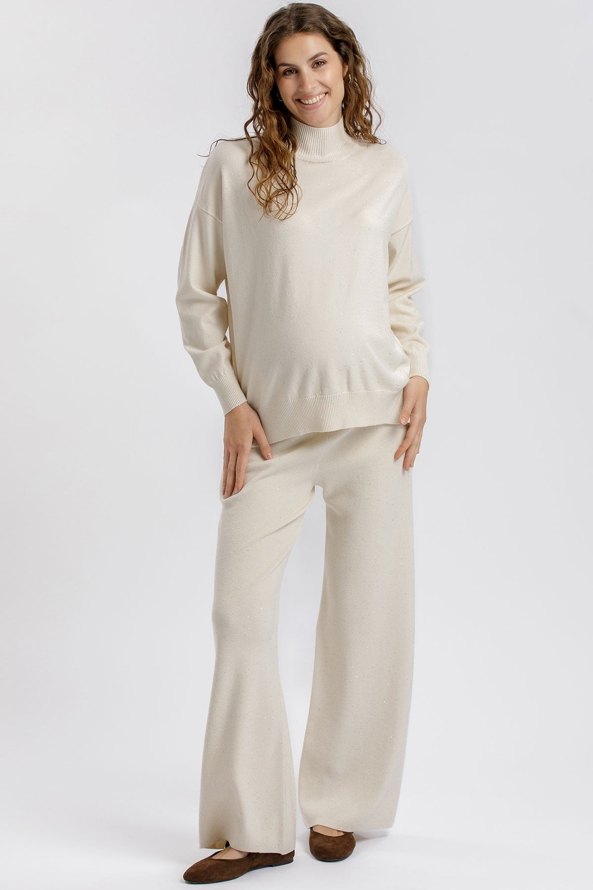 Maglia premaman crema con collo alto e dettagli luminosi. Vestibilità morbida e rilassata. Perfetta prima, durante e dopo la gravidanza