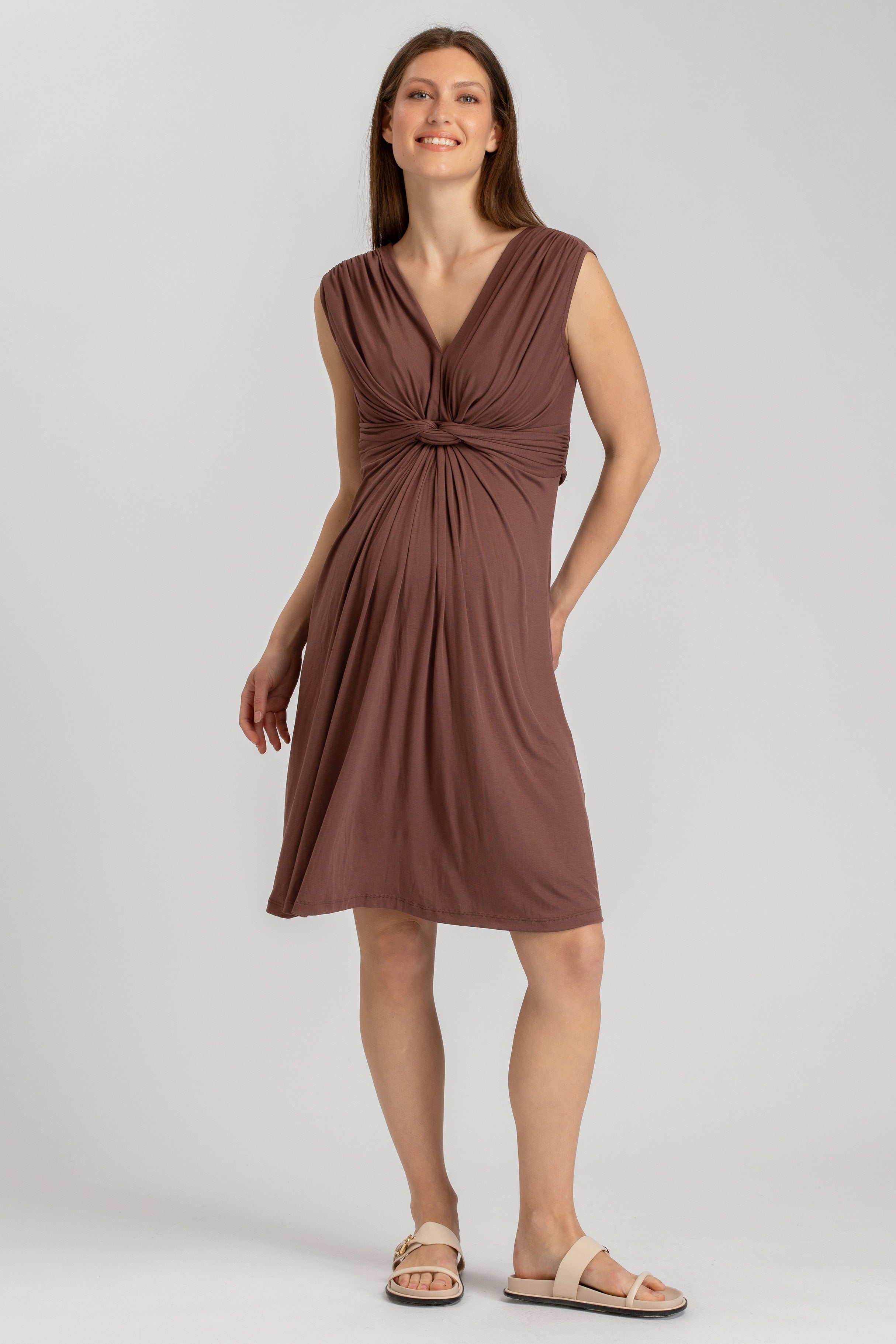 Donna indossa abito premaman marrone corto con nodo e scollo a V, stile elegante