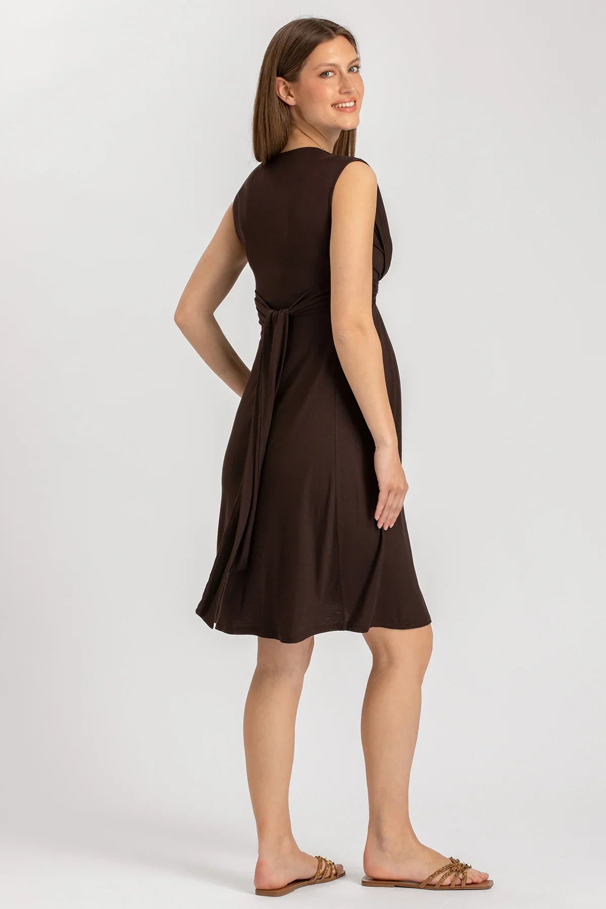 Vestito premaman marrone senza maniche, modello corto, con cintura, indossato da donna incinta.