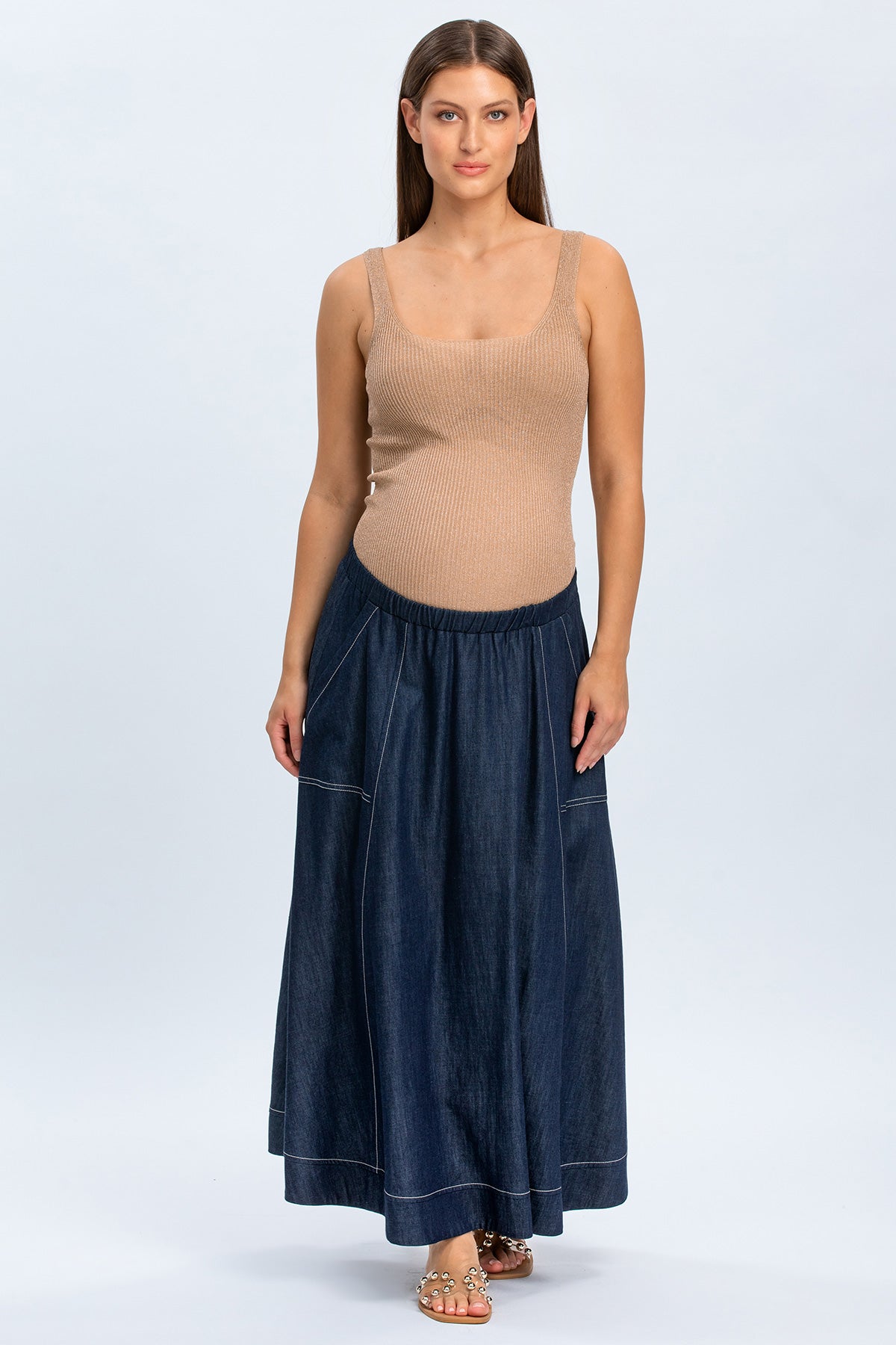 Modella indossa gonna lunga in denim premaman e top beige, abbigliamento premaman elegante