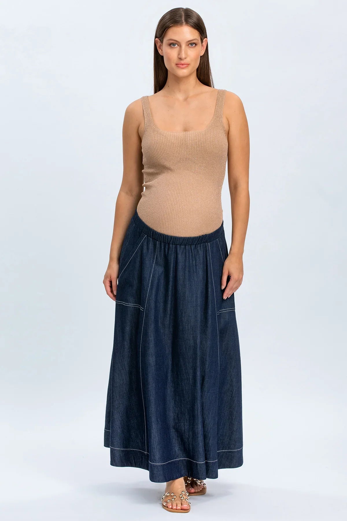 Modella indossa gonna lunga in denim premaman e top beige, abbigliamento premaman elegante