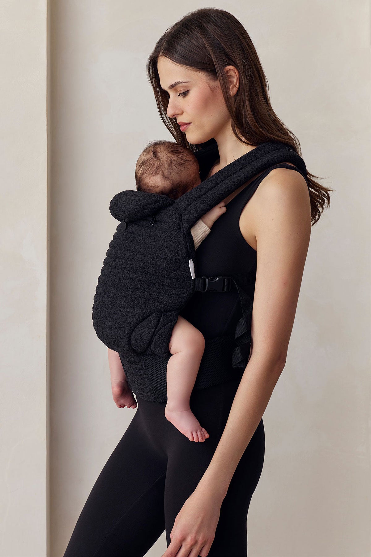Donna con abbigliamento premaman nero e marsupio porta bebè, comfort gravidanza
