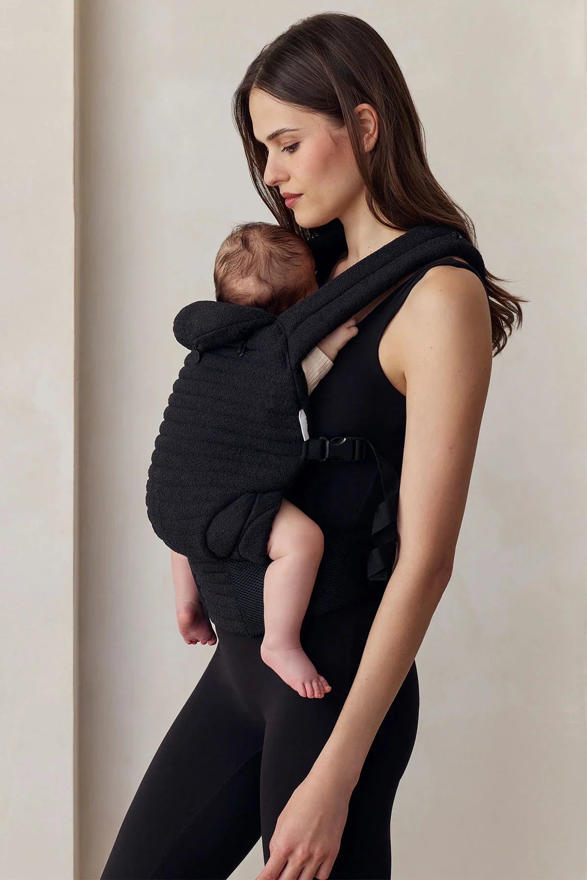 Donna con abbigliamento premaman nero e marsupio porta bebè, comfort gravidanza