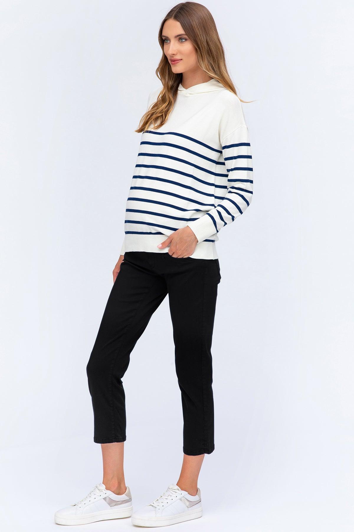 Modella che indossa maglione premaman bianco a righe blu e pantaloni neri cropped