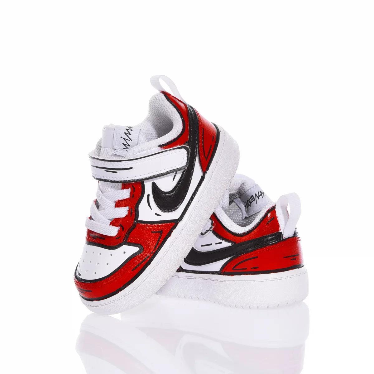 Scarpe da bambino bianche e rosse con dettagli neri e chiusura a strappo, su sfondo bianco.