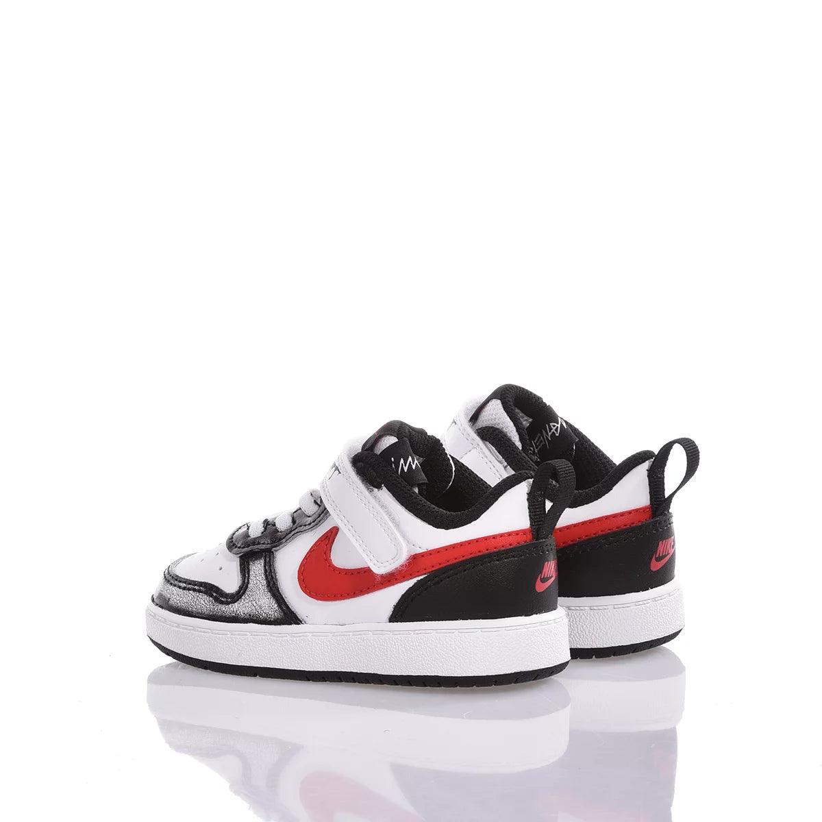 Scarpe sportive bambino bianche nere e rosse con chiusura a strappo su sfondo bianco