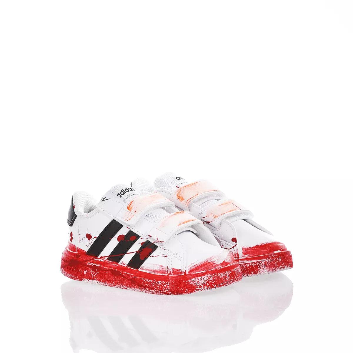Scarpe bianche con strisce nere e dettagli rossi, calzature sportive, adatte per outfit premaman casual.