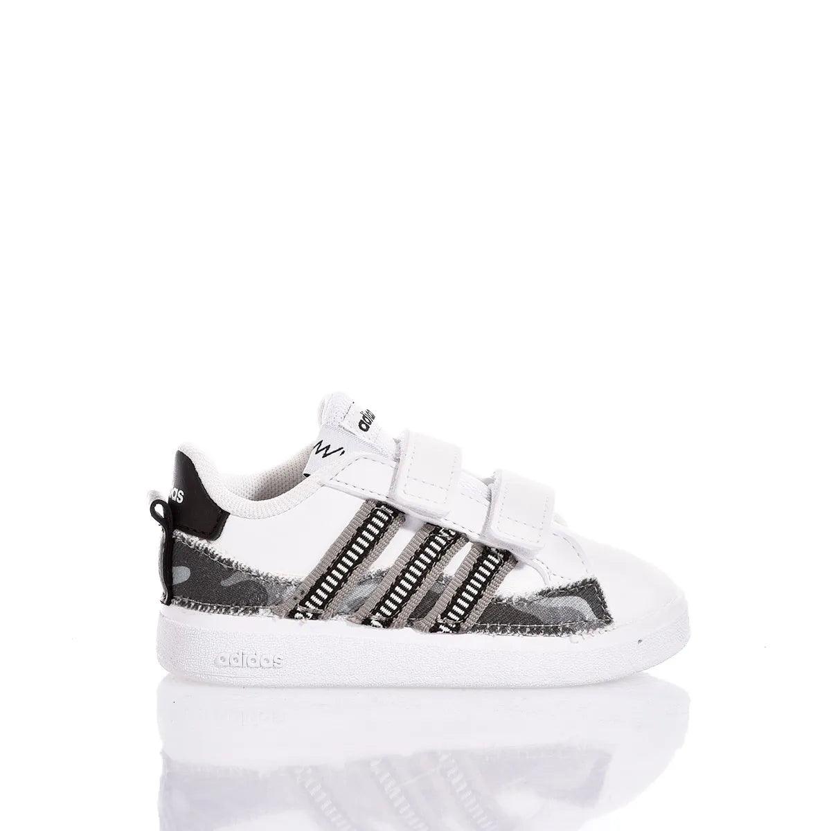 Scarpa sportiva bambino bianca con dettagli neri, ideale per look abbigliamento premaman casual.