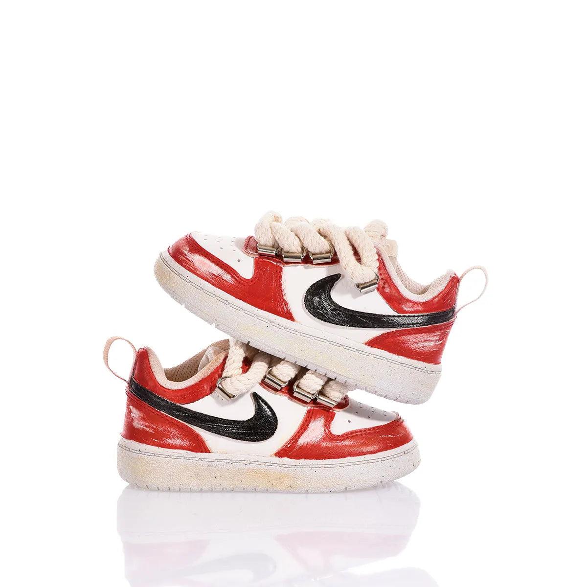 Sneaker bianche e rosse con dettagli neri, suola chiara e lacci spessi, stile casual.