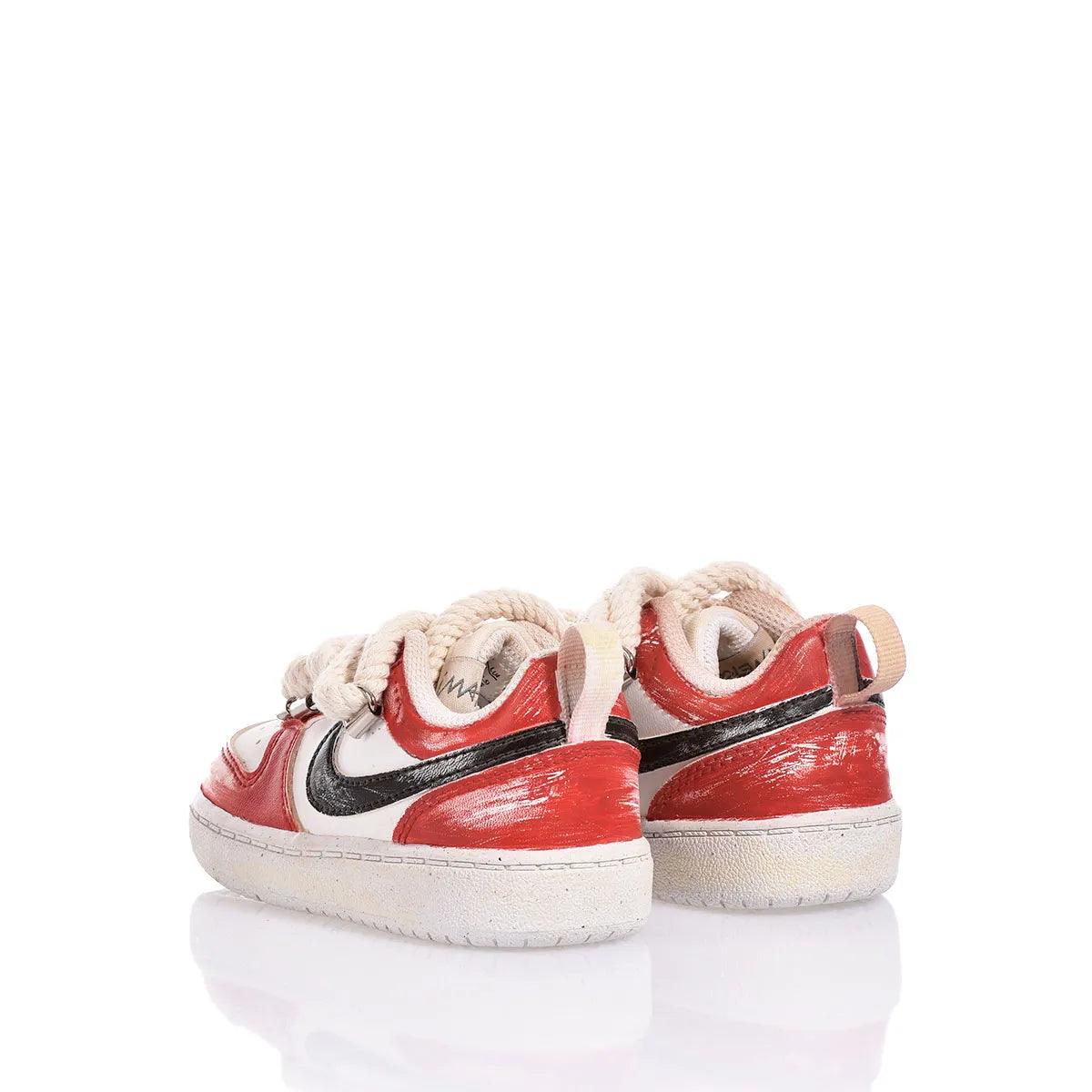 Sneakers bianche e rosse con dettagli neri e lacci spessi, su sfondo bianco.