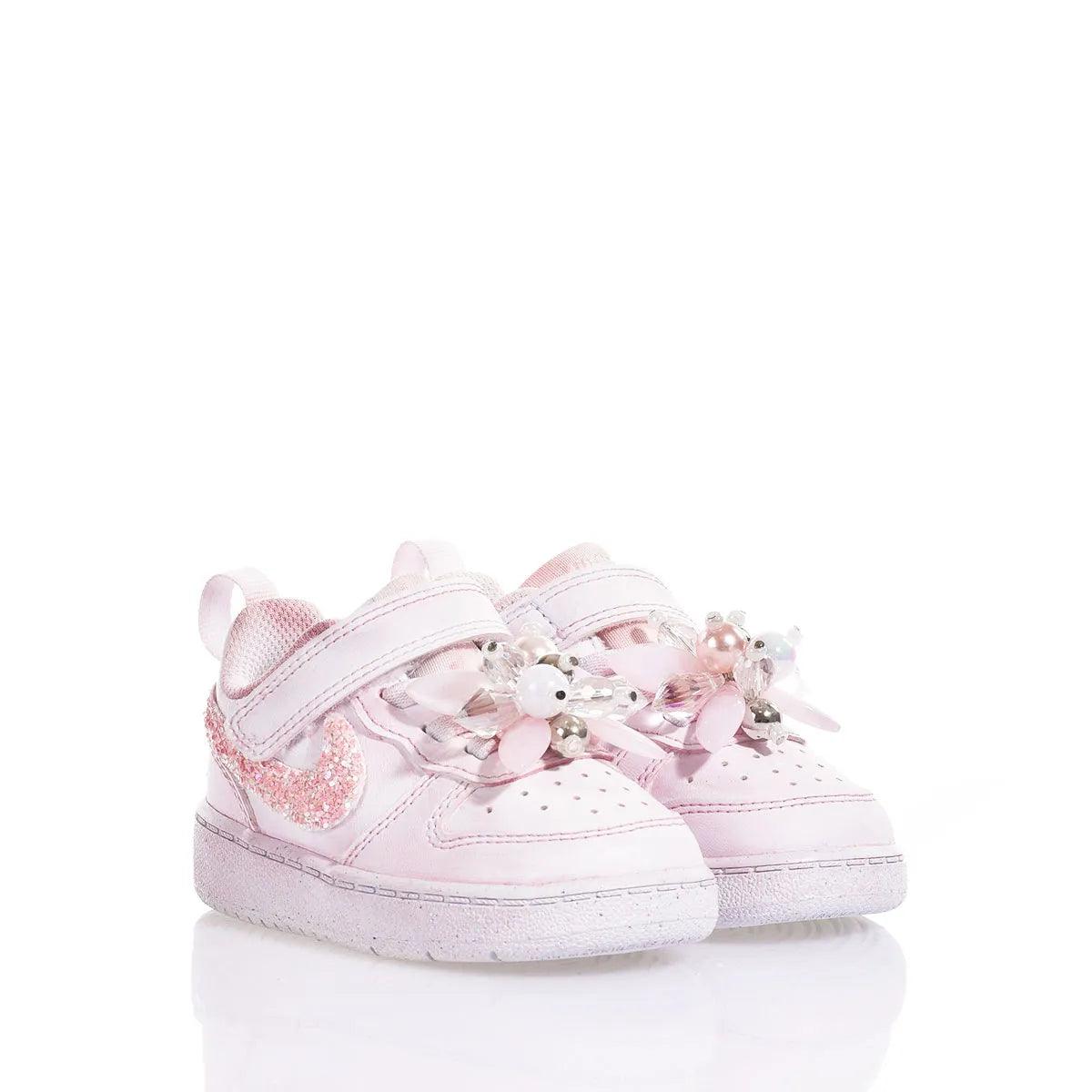 Scarpe neonato rosa con decorazioni floreali e glitter, chiusura a strappo, su fondo bianco