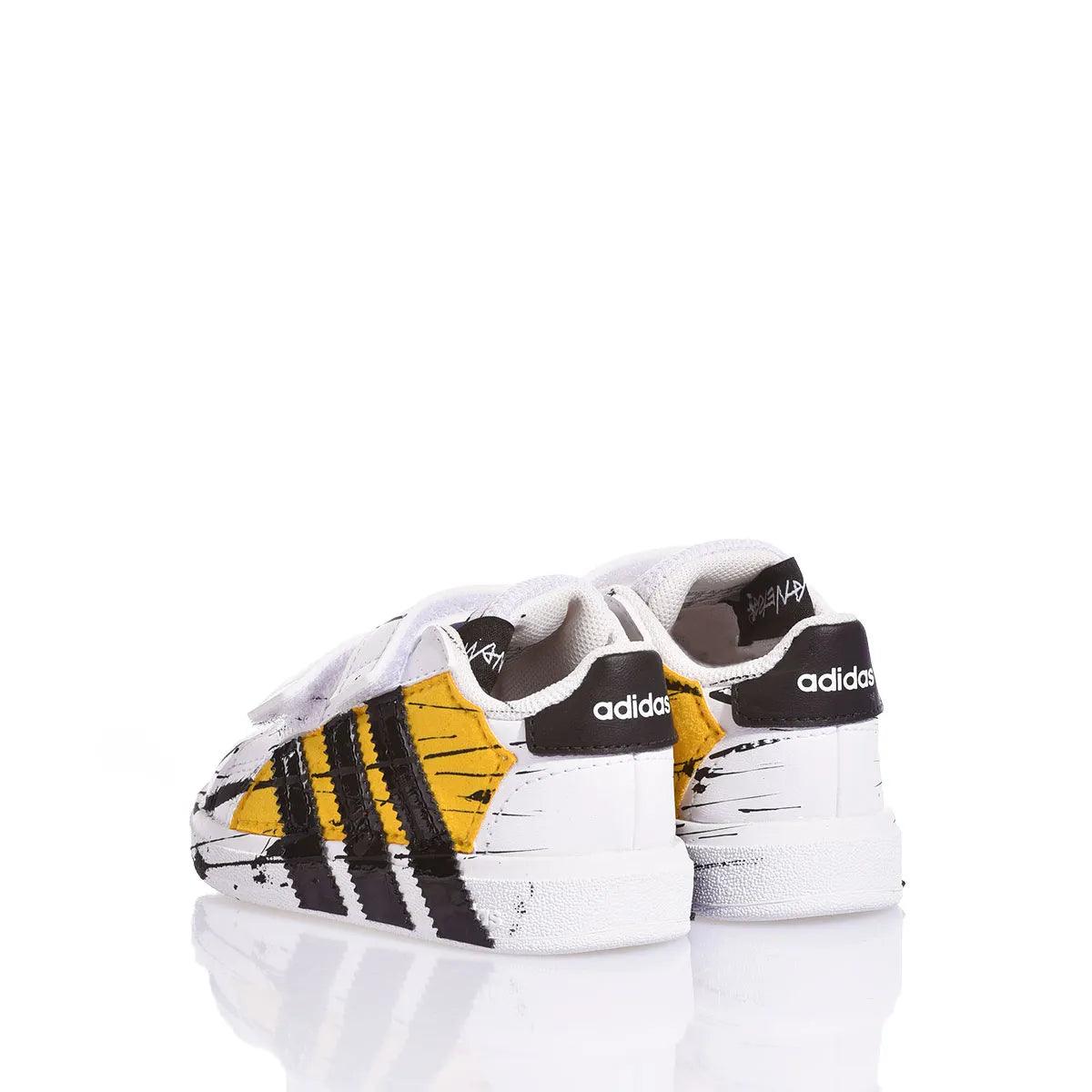 Scarpe sneakers bianche con dettagli gialli e neri, adatte per outfit premaman alla moda.