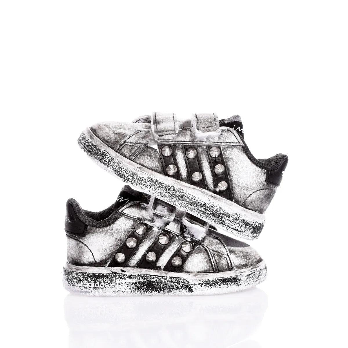 Scarpe da ginnastica argento con borchie per bambini, su sfondo bianco