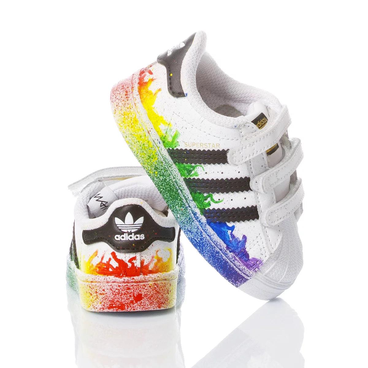 Sneakers bianche da bambino con dettagli arcobaleno colorati, adatte per look premaman casual.