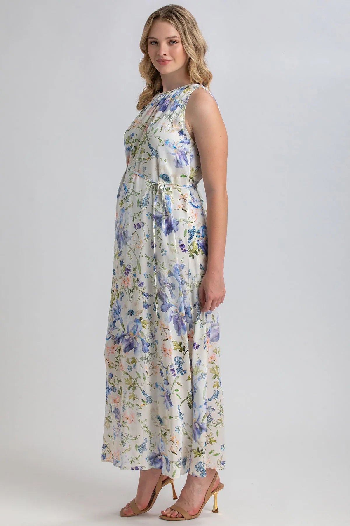 Vestito premaman lungo senza maniche con stampa floreale su fondo chiaro, donna in posa