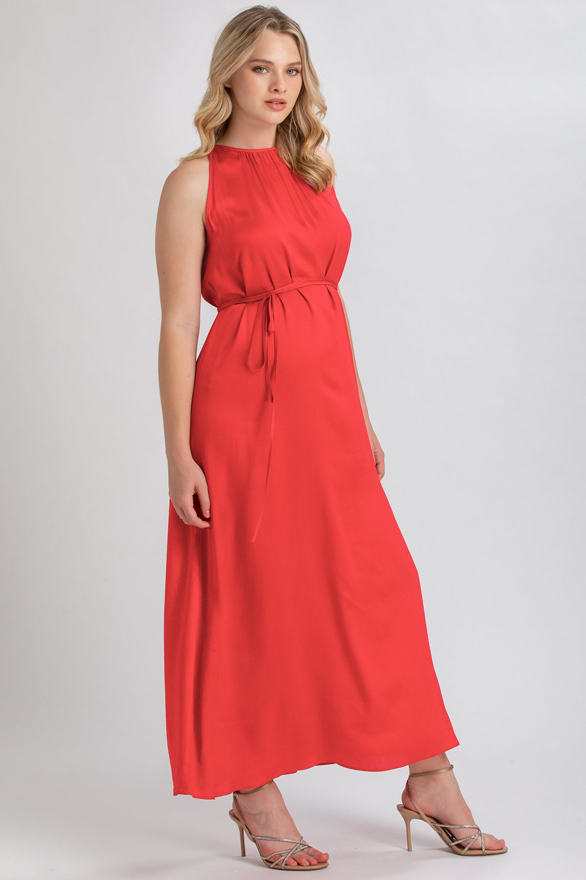 Abito premaman lungo rosso senza maniche, con cintura in vita, indossato da modella.