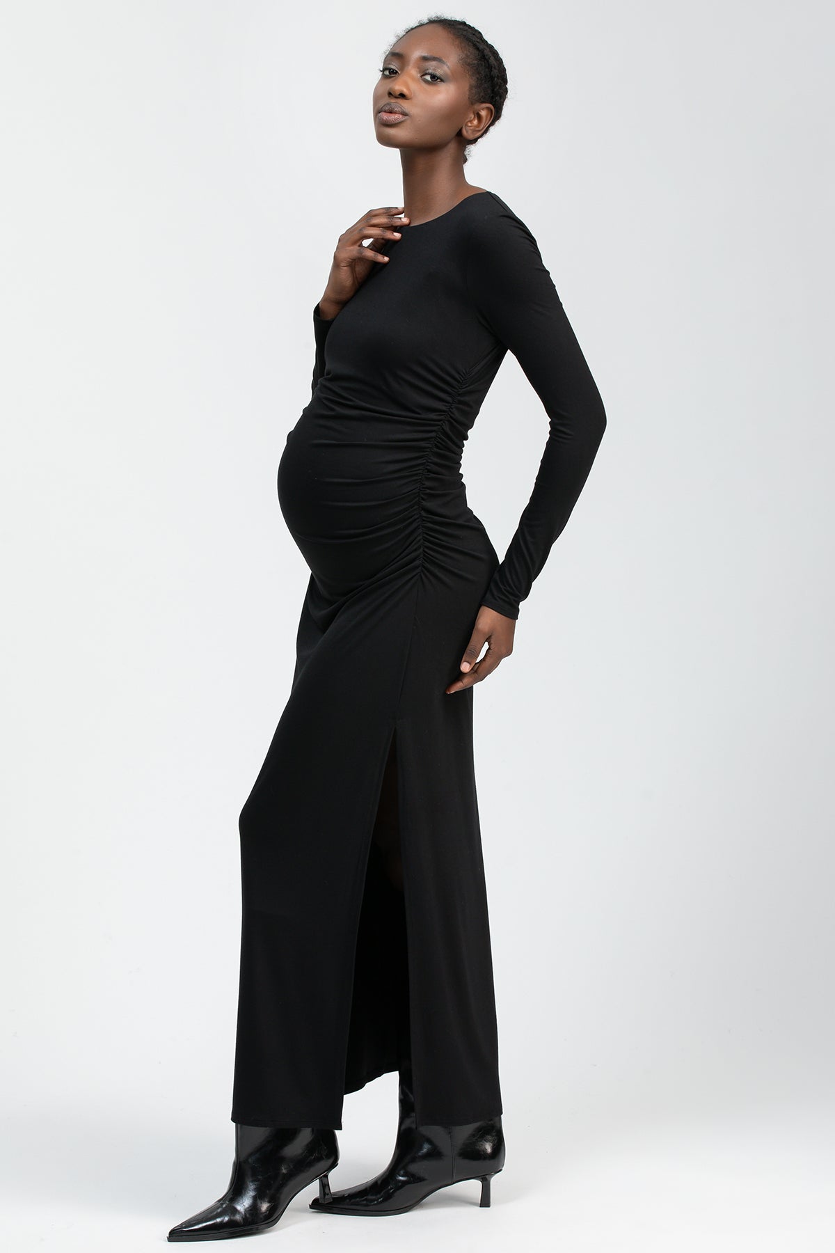 Fitted black maternity maxi dress featuring a round neckline and elegant side slit.