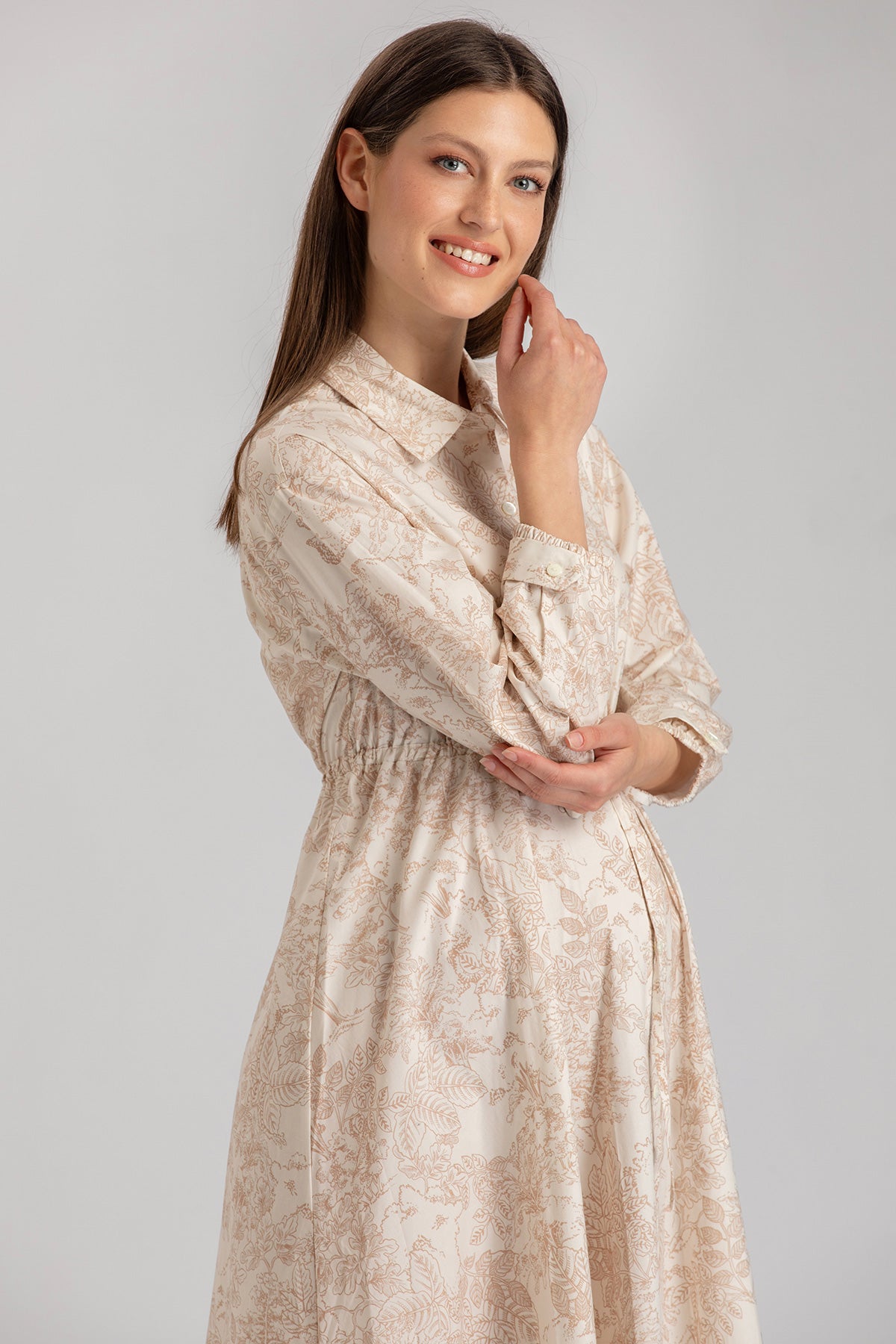 Abito premaman elegante beige a fantasia floreale, donna incinta sorridente in studio