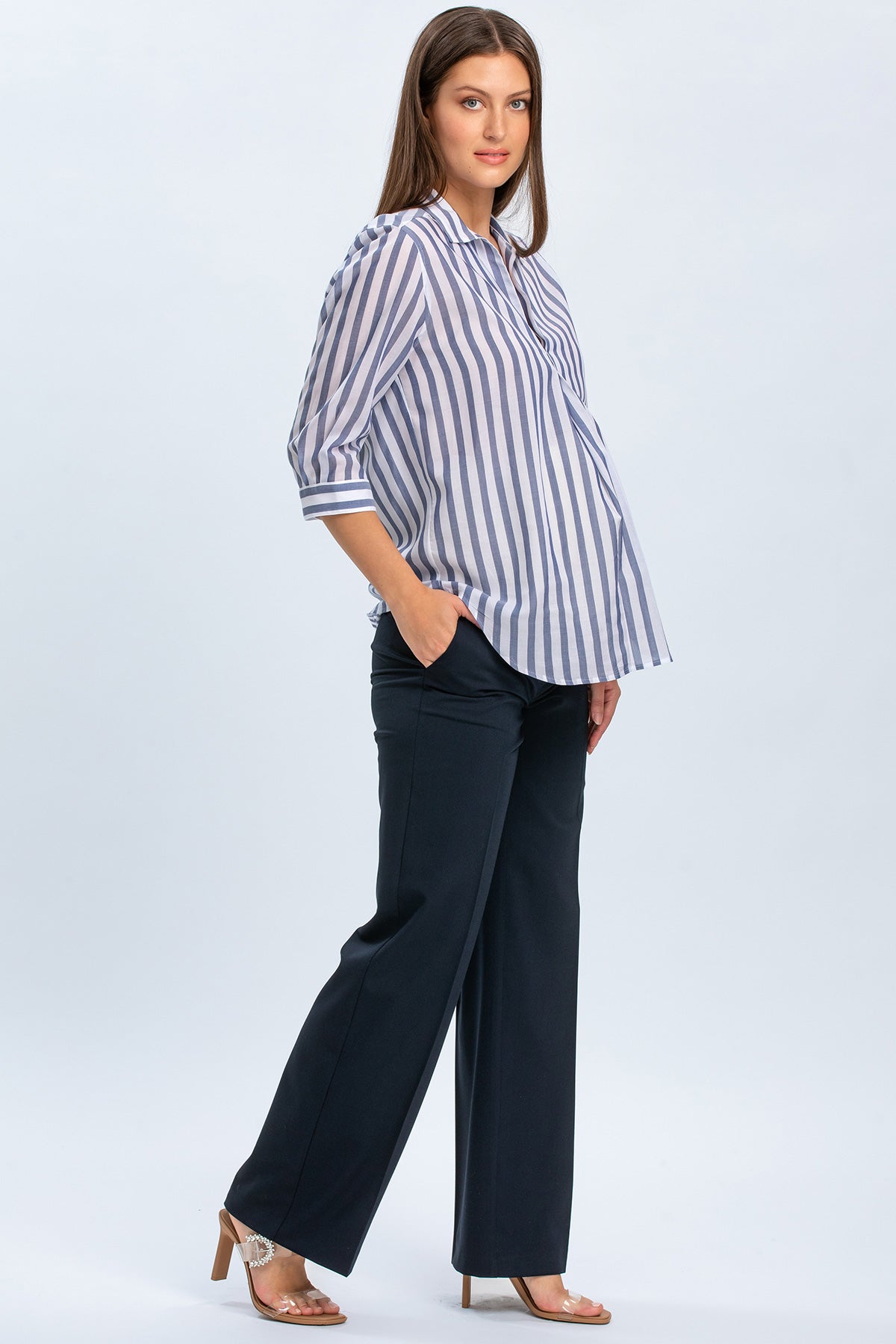 Modella indossa camicia premaman a righe con pantaloni eleganti premaman blu scuro