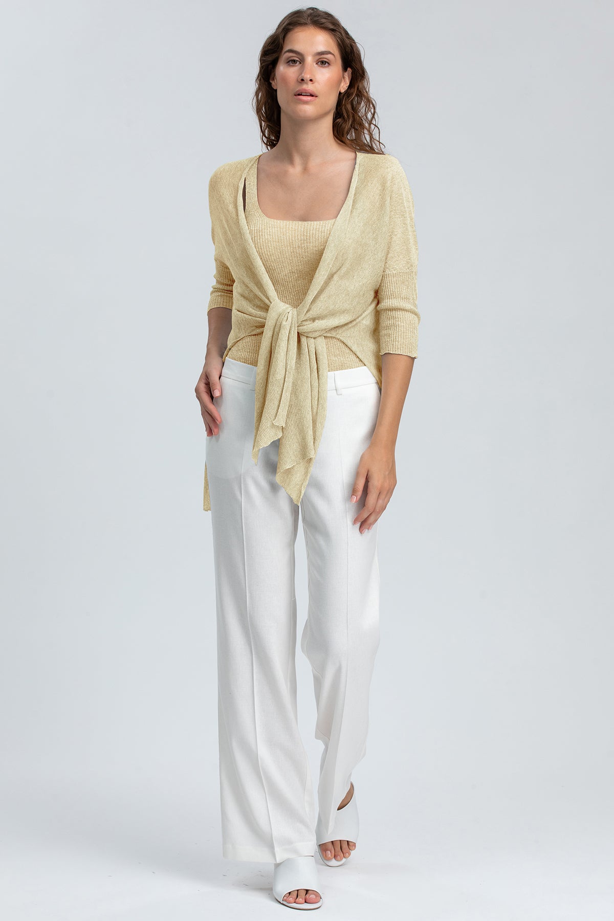 Donna con maglione premaman beige e pantaloni bianchi eleganti, abbigliamento premaman