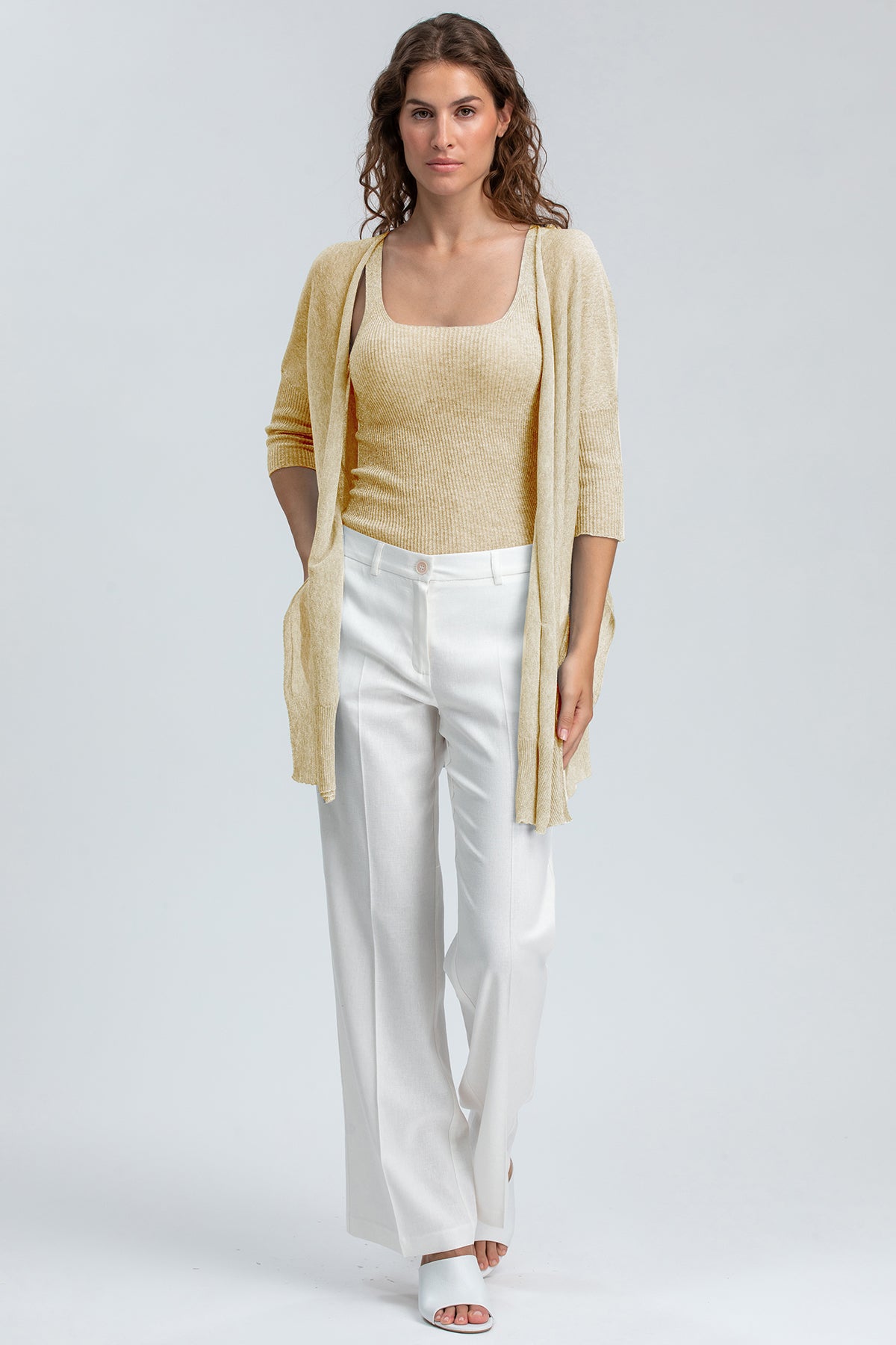 Abbigliamento premaman elegante: cardigan beige e pantaloni bianchi ampi per maternità