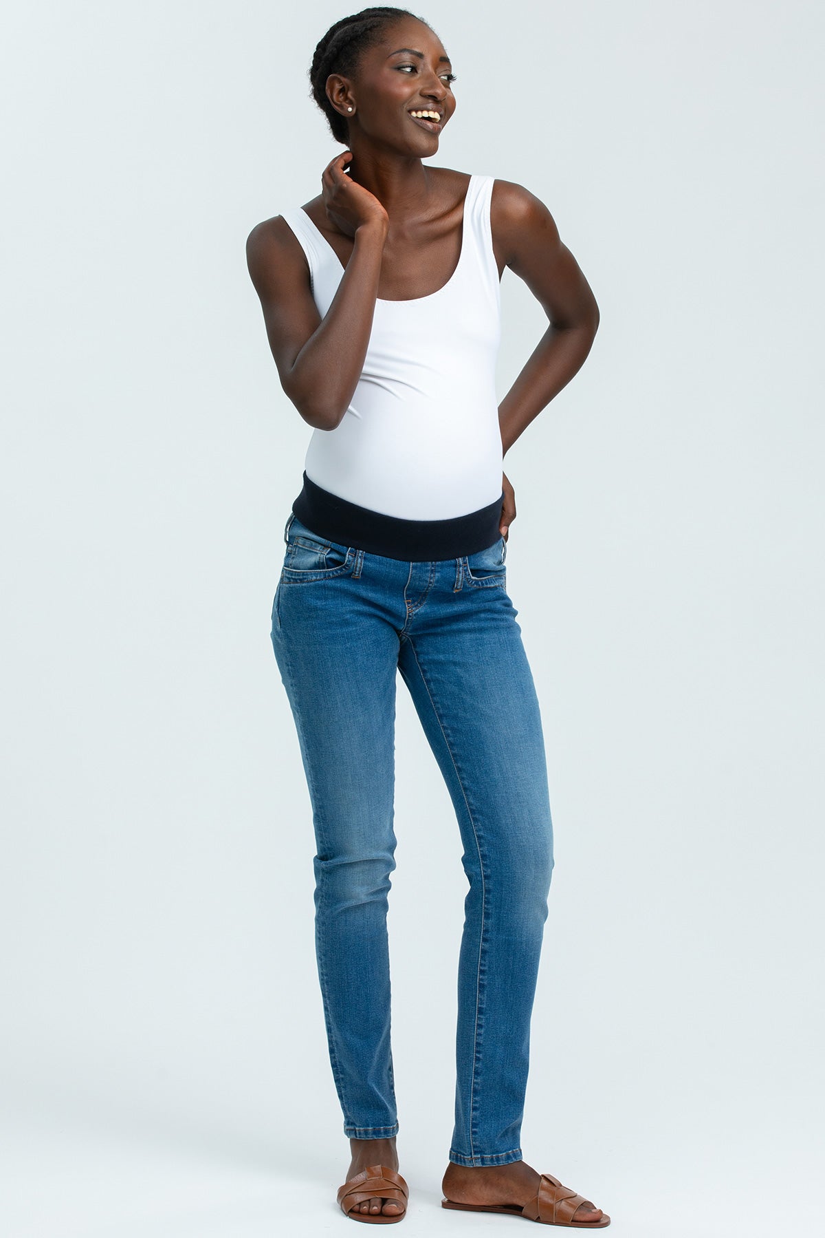 Modella indossa jeans premaman elasticizzati e top bianco, abbigliamento premaman casual