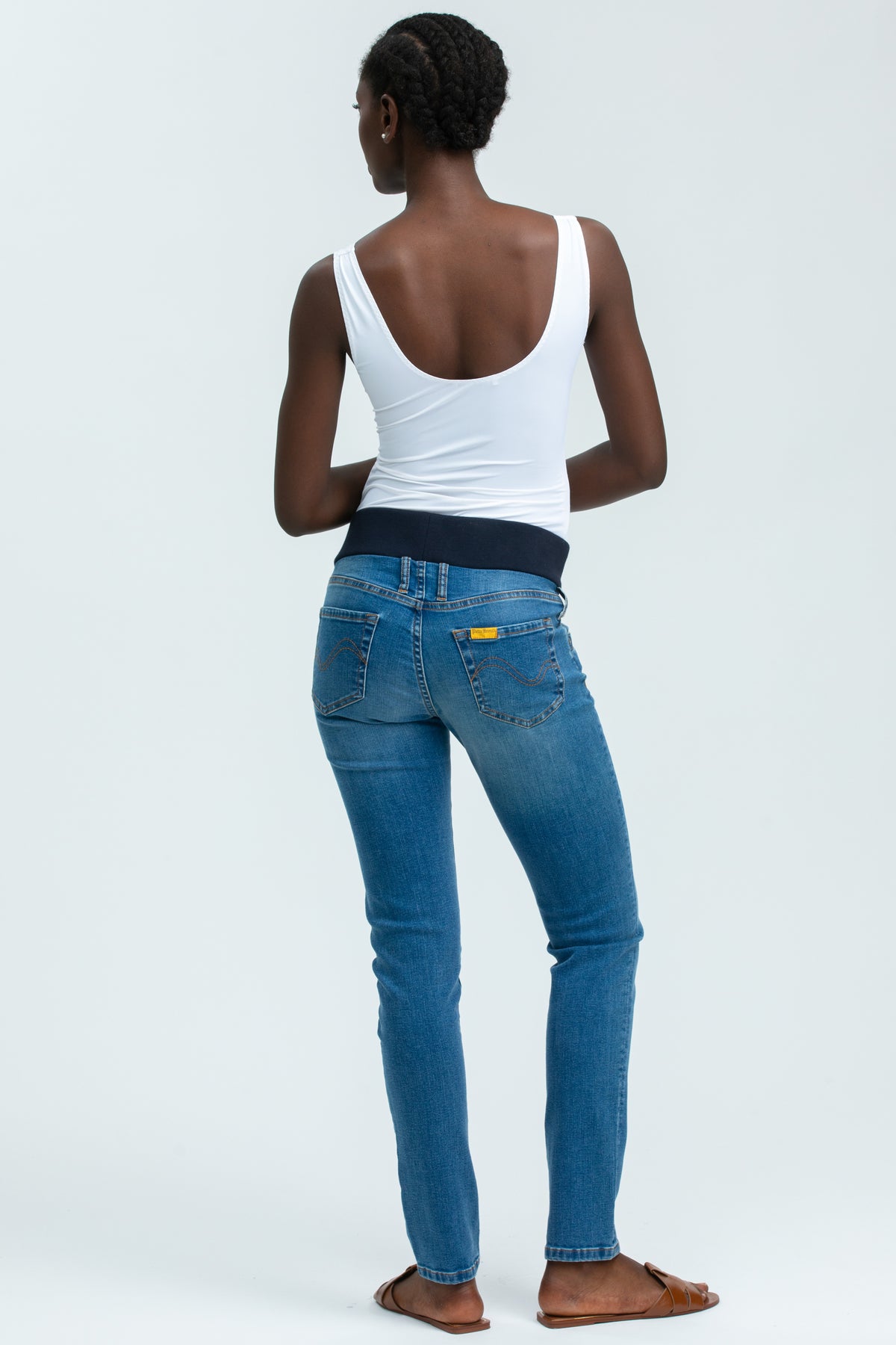 Jeans premaman elasticizzati blu con fascia in vita, indossati da donna su sfondo chiaro