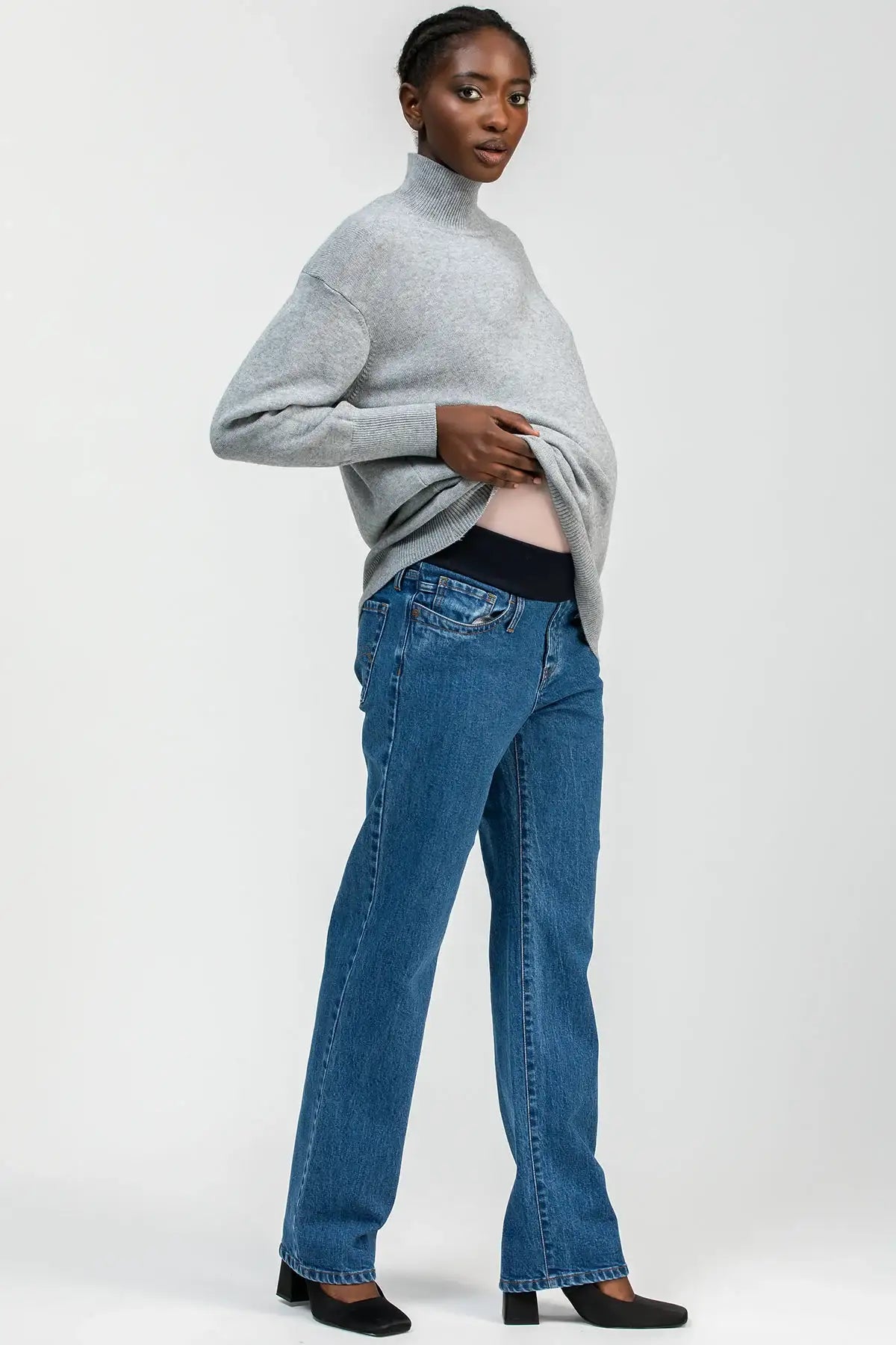 Model wearing high-waisted straight-leg maternity jeans with a comfortable stretchy belly band, styled for an elegant maternity look.