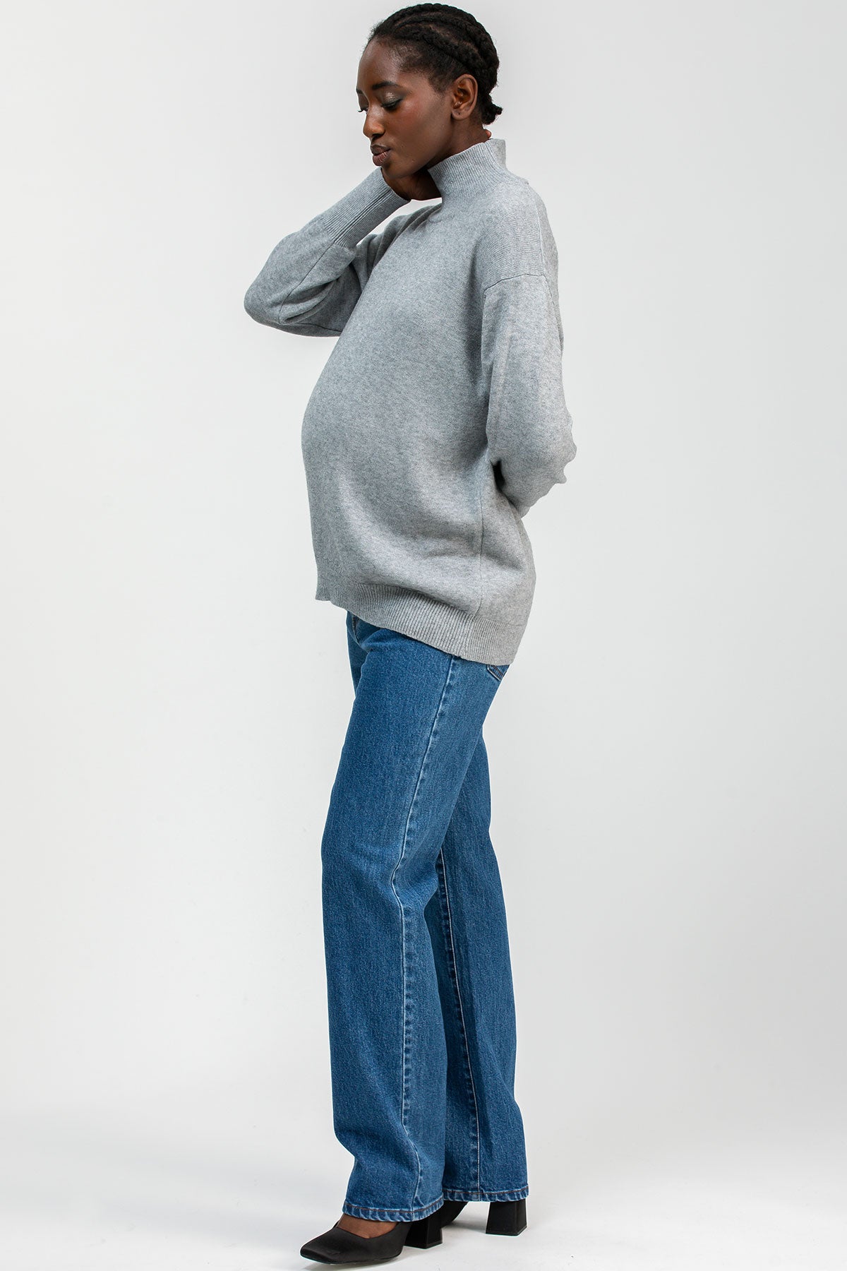 Modella indossa jeans premaman dritti a vita alta con fascia elastica comoda, abbigliamento premaman elegante.