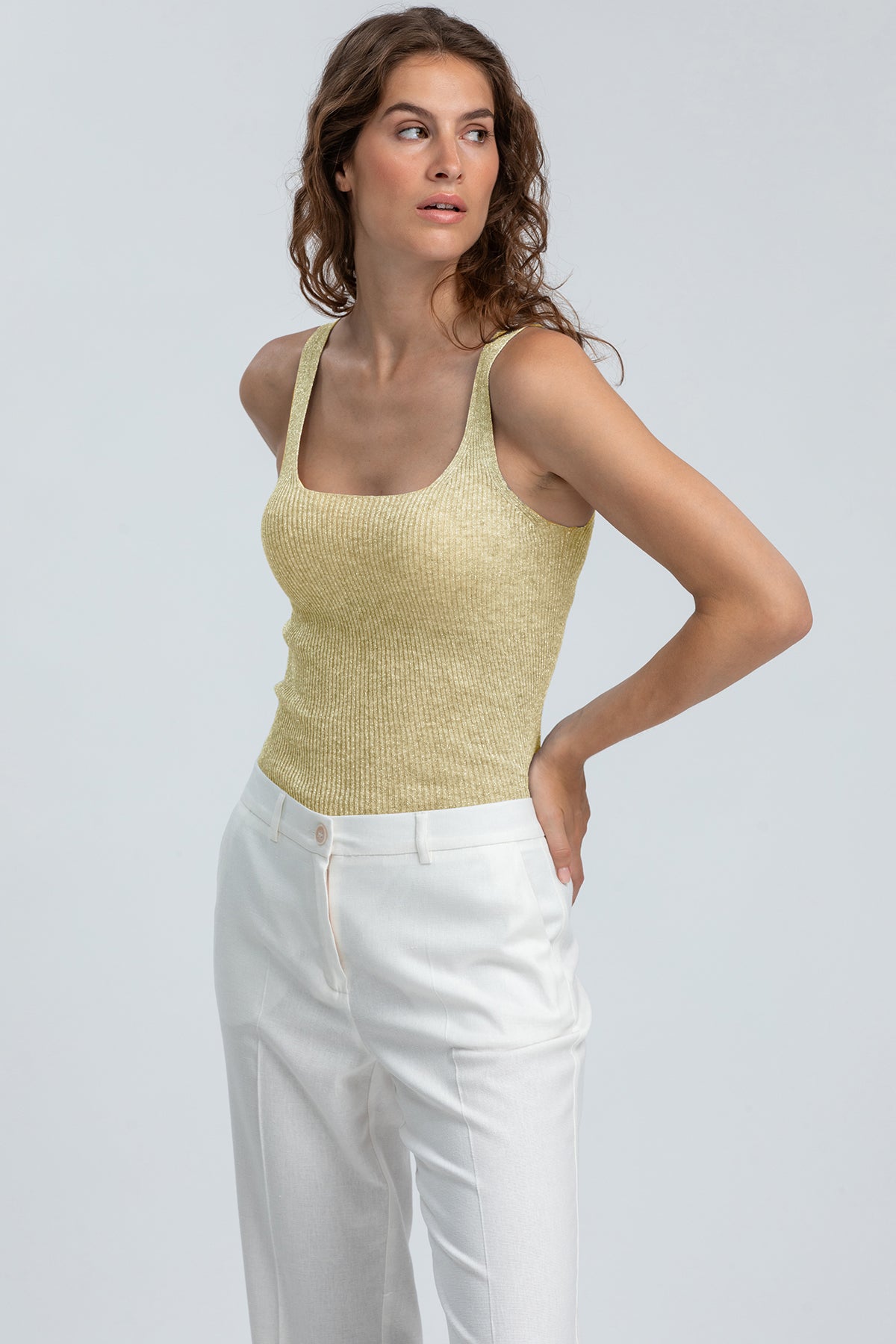 Top premaman senza maniche color oro e pantaloni bianchi eleganti per maternità