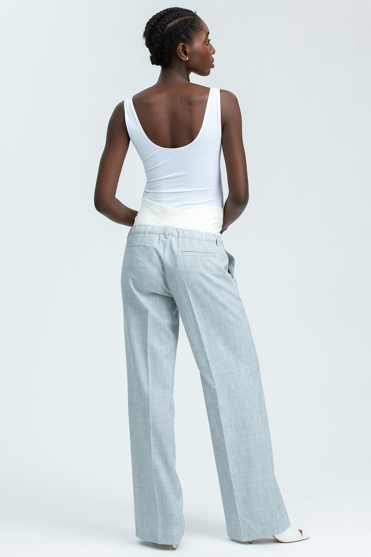 Pantaloni premaman grigi a gamba larga con fascia in jersey bianca, indossati da donna.