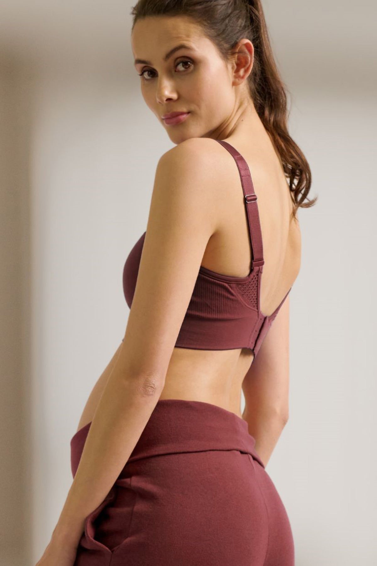 Donna incinta con reggiseno e pantaloni premaman bordeaux, abbigliamento premaman comodo